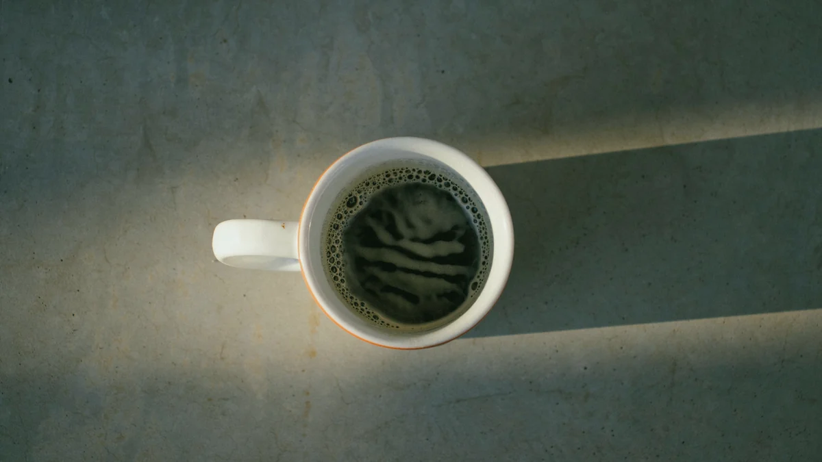 Taza blanca de café solo sobre una superficie gris con una franja de luz