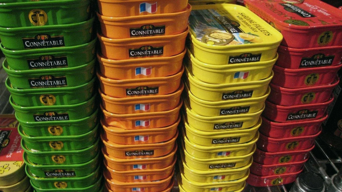 Latas de conserva de pescado apiladas en un lineal de supermercado