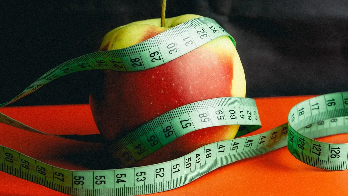 Manzana verde con una cinta métrica alrededor