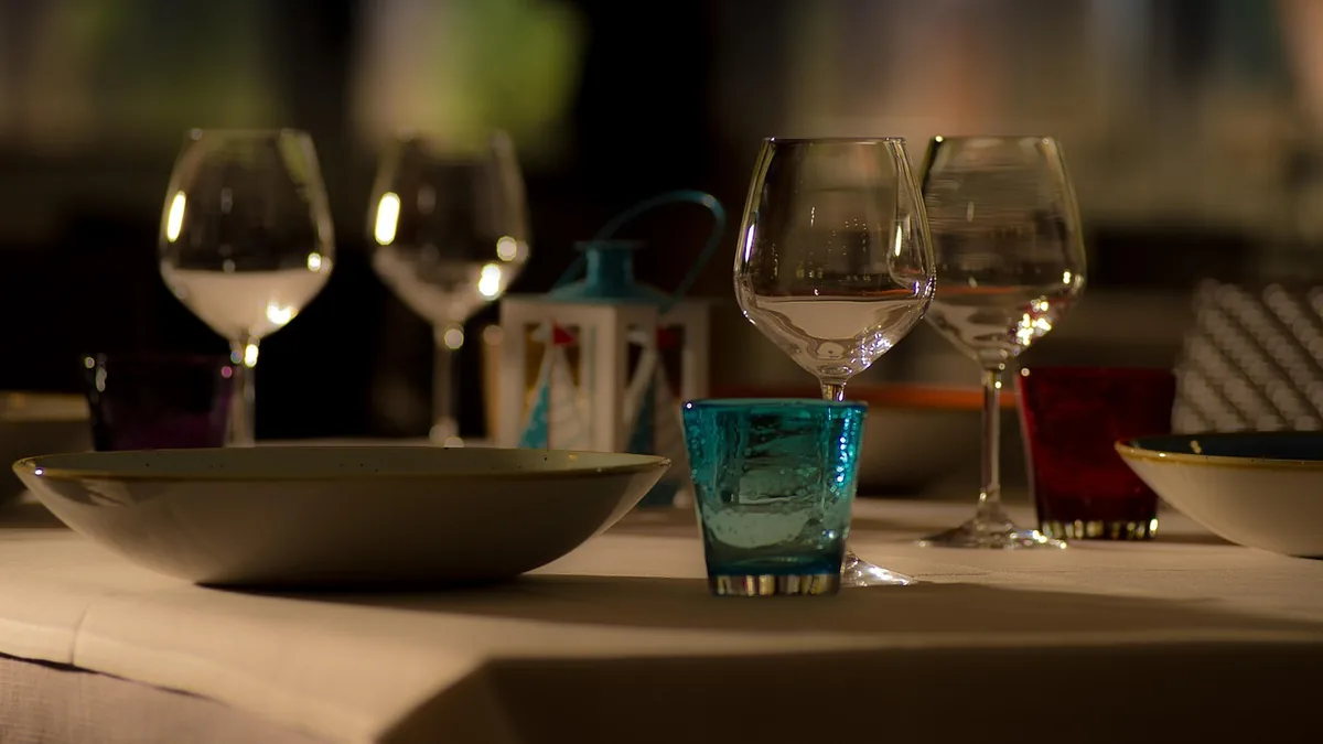 Mesa puesta con copas y vajilla, lista para cenar