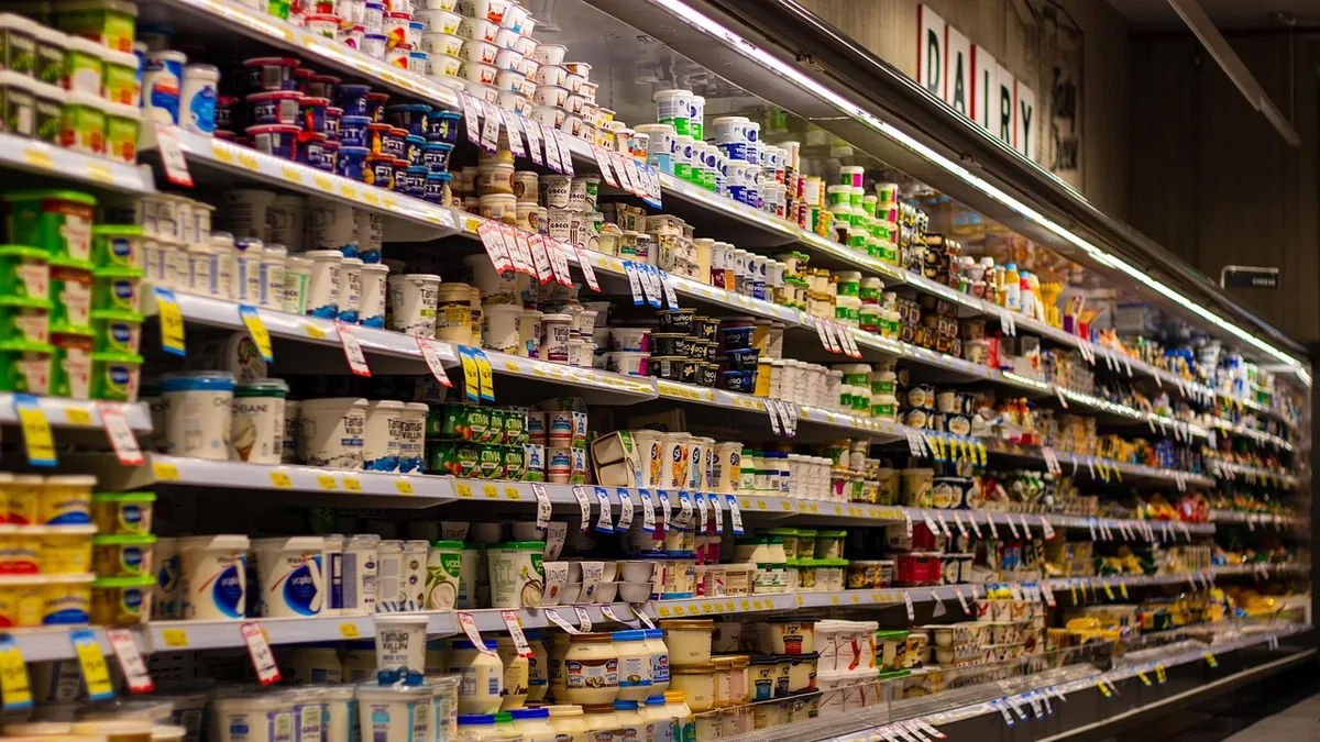 Pasillo refrigerado de un supermercado con estanterías de lácteos