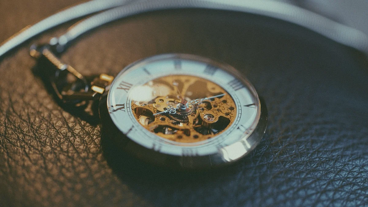 Reloj de bolsillo antiguo con la maquinaria a la vista sobre un fondo de cuero