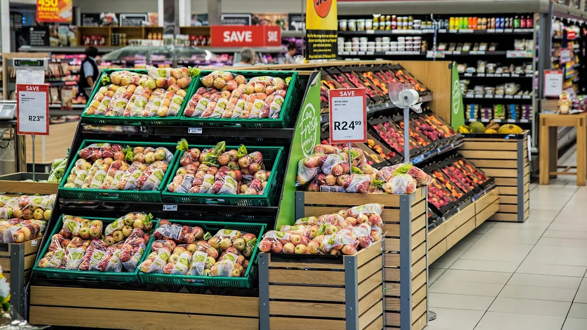 Sección de fruta y verdura de un supermercado con cajas de producto