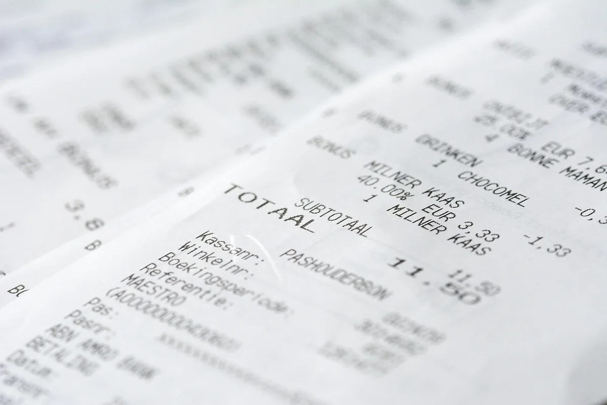 Tiques de compra apilados, con los importes y el total impresos